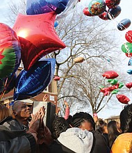 Dozens of people release colorful balloons in memory of 3-year-old Sharmar Hill Jr. during a prayer vigil last Saturday outside his family’s home in the 1700 block of Southlawn Avenue in Hillside Court. The youngster was shot and killed Feb. 1 as he played outside his home in the South Side public housing community.