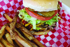 The Junkie Burger, which has vegan American cheese, smashed avocado, sautéed mushrooms and grilled onions, crispy onion strips, lettuce, pickles, tomato, with a garlic and onion aoli, is one of Plant Based Junkie Owner Bobbie Beaugard’s favorite menu items. Photo Credit: Bobbie Beaugard.