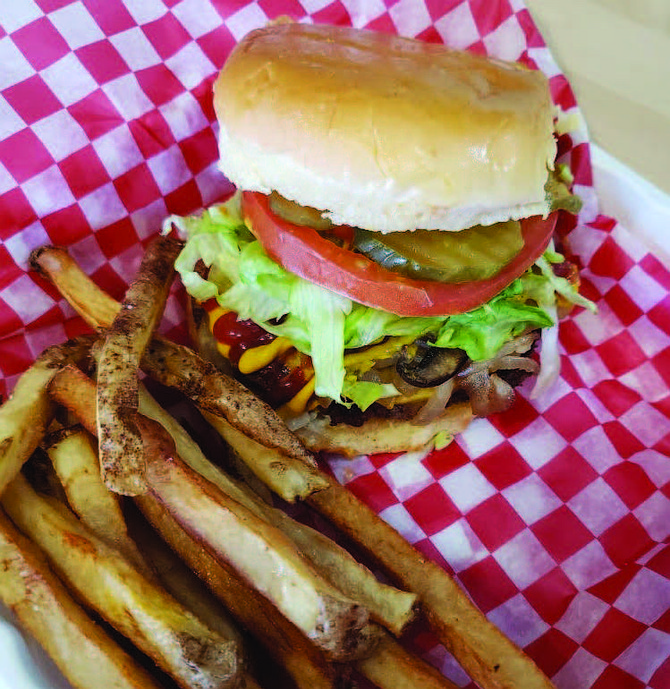 The Junkie Burger, which has vegan American cheese, smashed avocado, sautéed mushrooms and grilled onions, crispy onion strips, lettuce, pickles, tomato, with a garlic and onion aoli, is one of Plant Based Junkie Owner Bobbie Beaugard’s favorite menu items. Photo Credit: Bobbie Beaugard.