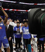 Kawhi Leonard of the Los Angeles Clippers holds up the Kobe Bryant MVP Award he won for his spectacular effort on Team LeBron in the All-Star Game.