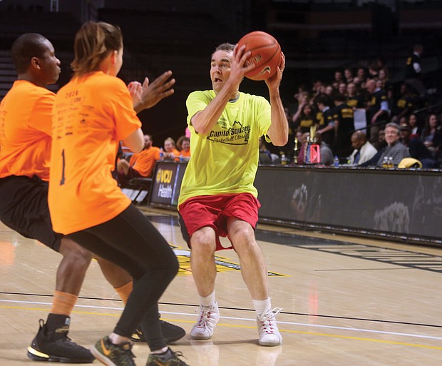 Gov. Ralph S. Northam looks for an open teammate to pass the ball to last Thursday during the 12th Annual Capitol Square Basketball Classic at Virginia Commonwealth University’s Siegel Center. The event was a fundraiser for VCU’s Massey Cancer Center.