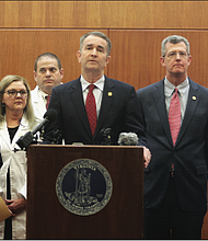 Gov. Ralph S. Northam, center, explains the state’s preparations for the coronavirus during a news conference Wednesday at the Patrick Henry Building in Downtown with several state officials. There have been no confirmed cases of the virus in Virginia so far.