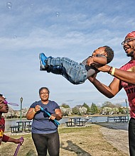 Shaun Yerby lifts his year-old son, Christian Moultrie, to catch bubbles blown by the youngster’s mother, Catrina Moultrie, and 7-year-old aunt, Ja’niyah Jackson during an outing Wednesday at Fountain Lake in Byrd Park. The sunny, 68-degree day was a draw for people who headed outdoors. Temperatures are expected to be in the low 60s by the weekend.