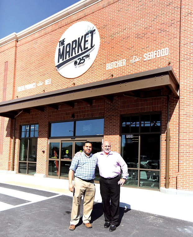 Norm Gold, right, developer and operator of The Market@25th, stands outside the grocery in Church Hill with store director Jae Scott before last April’s grand opening.