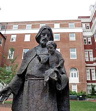 A Jesuit statue stands in front of Freedom Hall at Georgetown University in Washington. Students at the private university voted last year to add a fee to tuition to help pay for projects in communities that are home to descendants of the 272 slaves who were sold in 1838 by the university to help pay off the school’s debts.
