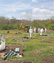 City employees dressed in hazmat suits Friday to clean up Cathy’s Camp on Oliver Hill Way. The property that belongs to Virginia Commonwealth University is to be fenced off to prevent a return of a homeless encampment.