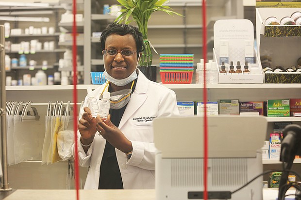 Dr. Shantelle L. Brown, owner of HOPE Pharmacy, shows the hand sanitizer the pharmacy is producing for free distribution to first responders. The sanitizer also is for sale to the public at the Church Hill pharmacy.