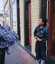 Ms. Shakoor gives 7-year-old Mansa Makamu, son of fellow 2nd Street merchant Ife Robinson, a dashiki from her store. It’s all a part of the connection.