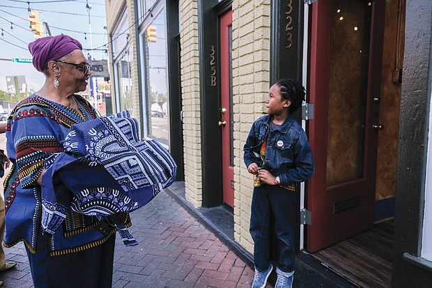 Ms. Shakoor gives 7-year-old Mansa Makamu, son of fellow 2nd Street merchant Ife Robinson, a dashiki from her store. It’s all a part of the connection.