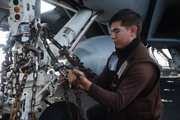 Aviation Structural Mechanic (Equipment) 3rd Class Daniel Mascheri, from Houston, performs a heavy weather tie down on a F/A-18F Super …