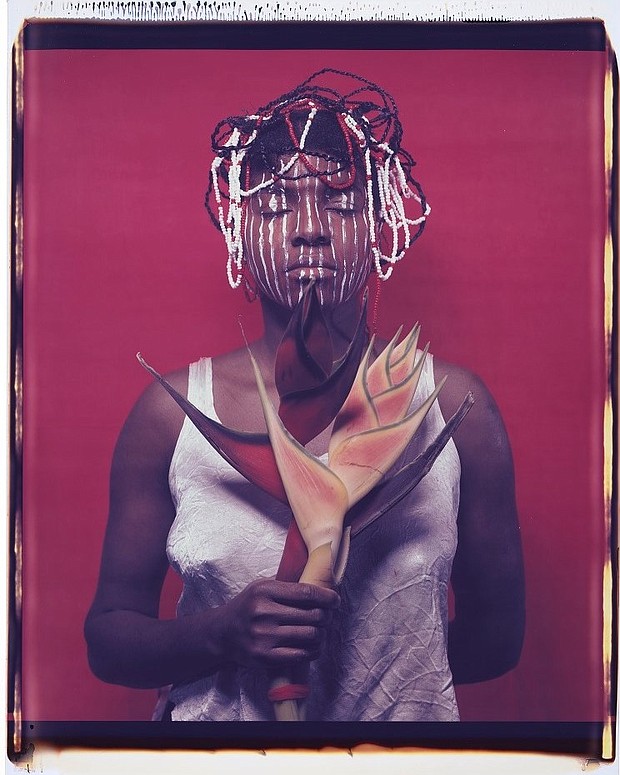 (Pictured above is the artwork by Maria Magdalena Campos-Pons, Untitled, from the series When I am not Here, Estoy alla. The artist used her own body to map out feelings of translocation from place to place. The bilingual title is in half-Spanish and means When I am not Here, I am There. She stands with her eyes closed, as though transported between territories while holding on to her Afro-Caribbean talismans. © María M. Campos-Pons. Dye diffusion transfer print (1996). National Portrait Gallery, Smithsonian Institution. Gift of Julia P. and Horacio Herzberg.)