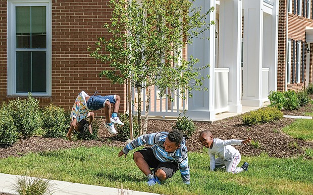 Montrell Mosley, 6, left, keeps the backflip and cartwheel party going as Demario Otey, 9, and Aiden Otey, 5, finish their rotations last Saturday in the 1700 block of Armstrong Way in Church Hill North.