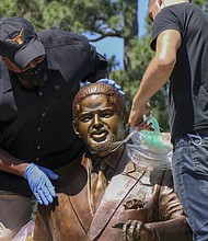 Harris County Commissioner Rodney Ellis, left, and CrateWorks Fine Art Services employee Bryan Hudson unwrap the late Congressman Mickey Leland statue that was installed in Hermann Park on Thursday, April 23.