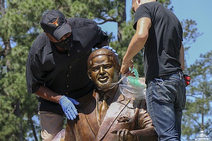 Harris County Commissioner Rodney Ellis, left, and CrateWorks Fine Art Services employee Bryan Hudson unwrap the late Congressman Mickey Leland statue that was installed in Hermann Park on Thursday, April 23.