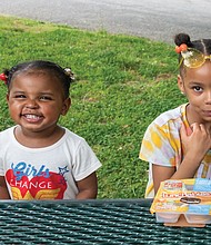 Harmony Johnson, 3, left, and her cousin, 6-year-old London Johnson, have lunch last Friday in Forest
Hill Park on South Side. They were enjoying the park and warm temperatures with London’s mom, Kristina Johnson. After scattered thunderstorms on Friday and Saturday, the Memorial Day weekend is expected to be sunny, with high temperatures in the mid to low 70s.