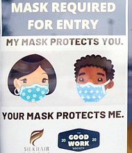 This sign on the front door of Silk Hair Studio reminds people that masks are required for entry into the building.