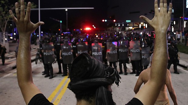 Police watch as demonstrators block a roadway while protesting the death of George Floyd in Miami. Photo: Joe Raedle/Getty Images