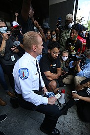 Police Chief Will smith takes a knee at a joint press conference with Mayor Levar M. stoney on Tuesday outside City Hall where they apologized to the crowd for police using tear gas and pepper spray on a peaceful crowd on Monday night at the Lee statue.