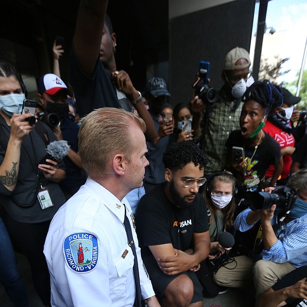 Police Chief Will smith takes a knee at a joint press conference with Mayor Levar M. stoney on Tuesday outside City Hall where they apologized to the crowd for police using tear gas and pepper spray on a peaceful crowd on Monday night at the Lee statue.