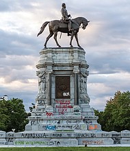 Daylight reveals the spray-painted pedestal of the Robert E. Lee statue at Monument and Allen avenues.