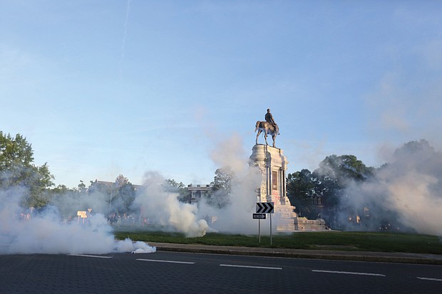 Tear gas clouds the air around the Monument Avenue statue of Confederate Gen. Robert E. Lee on Monday evening when Richmond Police scattered hundreds of peaceful protesters by releasing tear gas and shooting pepper spray about 30 minutes before the 8 p.m. curfew was to go into effect. The Confederate statues are headed for removal under plans announced Wednesday.