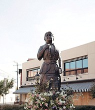 A ring of flowers adorns the Maggie L. Walker statue at Broad and Adams streets in Downtown, the result of efforts by Vessel + Stem floral design studio to honor the renowned businesswoman during city protests in late May.