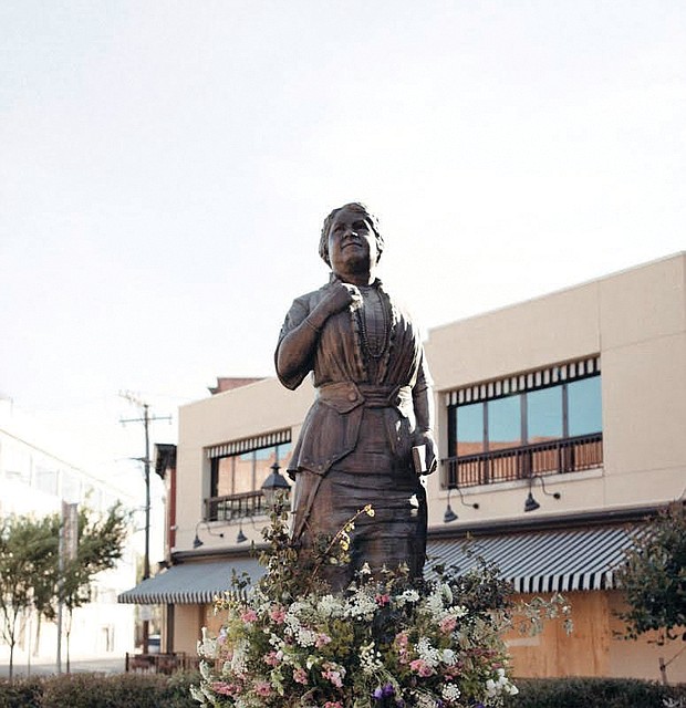 A ring of flowers adorns the Maggie L. Walker statue at Broad and Adams streets in Downtown, the result of efforts by Vessel + Stem floral design studio to honor the renowned businesswoman during city protests in late May.