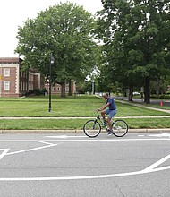 A cyclist pedals along one of the newly installed bike lanes on Brook Road near Westbrook Avenue. A sign explains that parking is allowed to the left in a former travel lane, while bikes stay to the right. More than $1 million in federal funds was spent to install the 3.5-mile stretch in Richmond of bike lanes along Brook Road between Azalea Avenue and Charity Street. Providing room for bikes and street parking is restricting vehicle traffic to one lane in each direction on Brook Road, although there are turn lanes for vehicles at major intersections. Work began after City Hall shut down in mid-March due to the pandemic and is essentially complete. The total $1.5 million installation project also included funding for bike lanes on Malvern Avenue and a portion of Patterson Avenue, according to the city Department of Public Works.