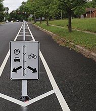 A sign explains that parking is allowed to the left in a former travel lane, while bikes stay to the right. More than $1 million in federal funds was spent to install the 3.5-mile stretch in Richmond of bike lanes along Brook Road between Azalea Avenue and Charity Street. Providing room for bikes and street parking is restricting vehicle traffic to one lane in each direction on Brook Road, although there are turn lanes for vehicles at major intersections. Work began after City Hall shut down in mid-March due to the pandemic and is essentially complete. The total $1.5 million installation project also included funding for bike lanes on Malvern Avenue and a portion of Patterson Avenue, according to the city Department of Public Works.