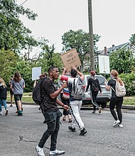 Members of the 381 Movement march along Hawthorne Avenue in North Side for education reform on Monday.