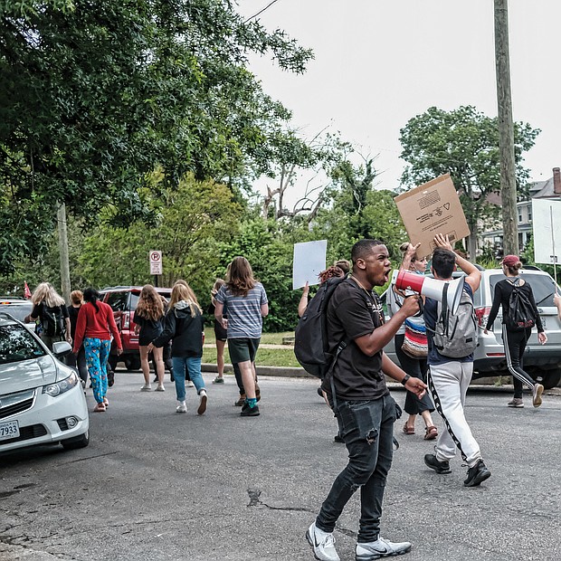 Members of the 381 Movement march along Hawthorne Avenue in North Side for education reform on Monday.