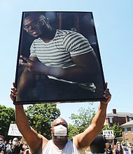 Jeffrey L. Peters of Middlesex County holds a photo of his nephew, Marcus-David Peters, 24, a high school biology teacher who was fatally shot by a Richmond Police officer in 2018 during what has been described as a mental crisis. Mr. Peters was taking part in the 5000 Man March on Saturday at the Lee statue and raising awareness of the slaying.