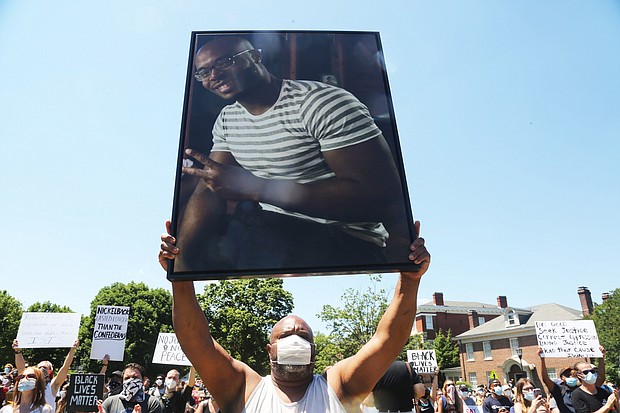 Jeffrey L. Peters of Middlesex County holds a photo of his nephew, Marcus-David Peters, 24, a high school biology teacher who was fatally shot by a Richmond Police officer in 2018 during what has been described as a mental crisis. Mr. Peters was taking part in the 5000 Man March on Saturday at the Lee statue and raising awareness of the slaying.