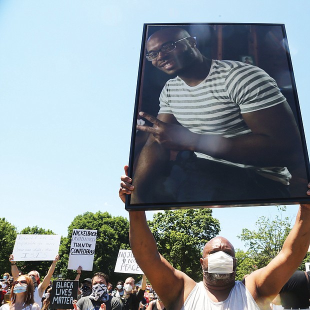 Jeffrey L. Peters of Middlesex County holds a photo of his nephew, Marcus-David Peters, 24, a high school biology teacher who was fatally shot by a Richmond Police officer in 2018 during what has been described as a mental crisis. Mr. Peters was taking part in the 5000 Man March on Saturday at the Lee statue and raising awareness of the slaying.