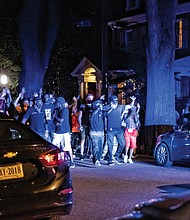 Blue lights illuminate protesters who react after a police SUV runs into a cyclist on Monument Avenue around 9:30 p.m. Saturday.