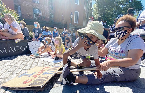 Nelson Foster, 4, participates at the RVA Youth Rally last Saturday with his grandmother, Rita Flowers. The rally drew young people and families to the statue of Maggie L. Walker at Broad and Adams streets in Downtown.