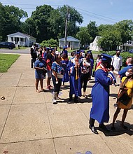 A line of seniors and their families wait outside Armstrong High School on Tuesday for their turn to enter the building for the ceremony where diplomas were awarded one student at a time to curb the spread of COVID-19.