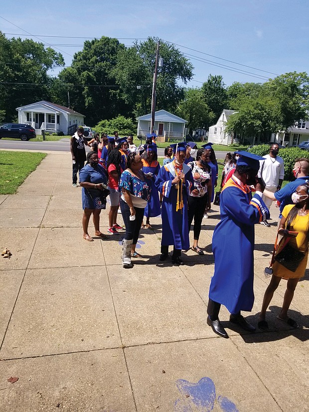 A line of seniors and their families wait outside Armstrong High School on Tuesday for their turn to enter the building for the ceremony where diplomas were awarded one student at a time to curb the spread of COVID-19.