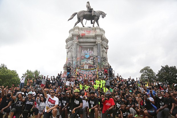 Cyclists participating in the Black Lives Matter Father’s Day Bike Ride pause to take a group picture Sunday in front of the Lee statue during the ride through the city.The Urban Cycling Group and R&B singer Trey Songz organized the unifying event that drew hundreds to ride peacefully through the city.