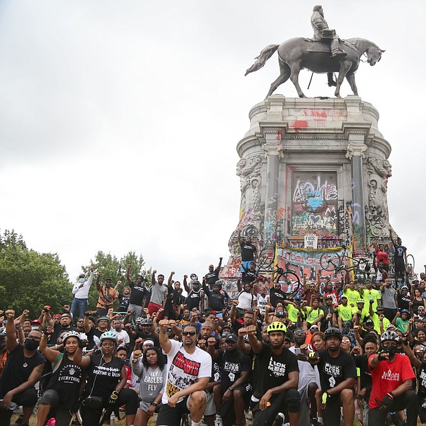 Cyclists participating in the Black Lives Matter Father’s Day Bike Ride pause to take a group picture Sunday in front of the Lee statue during the ride through the city.The Urban Cycling Group and R&B singer Trey Songz organized the unifying event that drew hundreds to ride peacefully through the city.