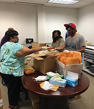 From left, Mary Carter, Sharon Stone and Arqam Ahsan with the state Department of Medical Assistance Services pack masks and other personal protection equipment for home health care workers who aid thousands of elderly and disabled Virginians with bathing, dressing, toileting and meals under the Medicaid program.