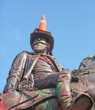 a traffic cone is propped on the head of Confederate Gen. J.E.B. Stuart and a rope is around his neck Monday, evidence of the Sunday night effort to pull him off his pedestal at Lombardy Street and Monument Avenue. Richmond and State Police used tear gas and other means to stop the protesters from taking the statue down.