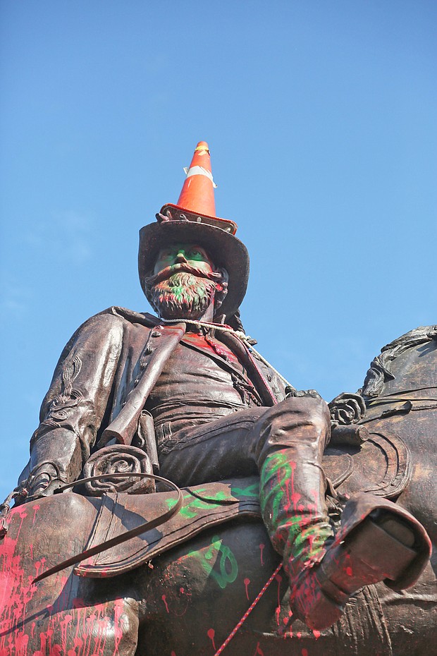 a traffic cone is propped on the head of Confederate Gen. J.E.B. Stuart and a rope is around his neck Monday, evidence of the Sunday night effort to pull him off his pedestal at Lombardy Street and Monument Avenue. Richmond and State Police used tear gas and other means to stop the protesters from taking the statue down.