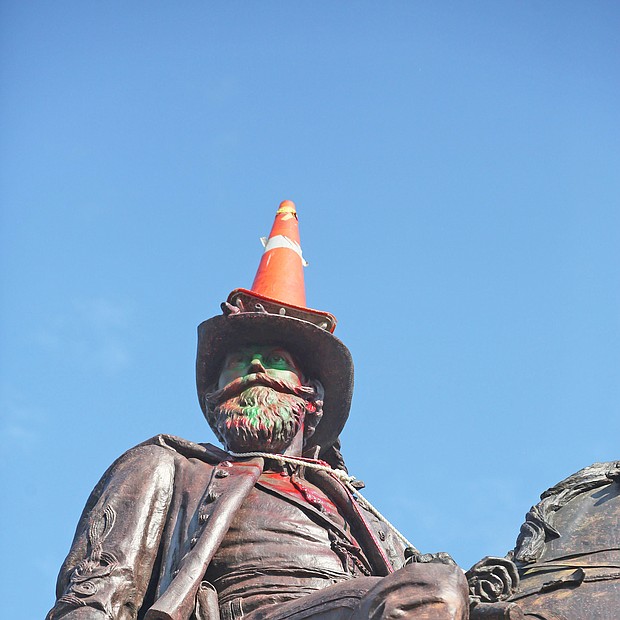 a traffic cone is propped on the head of Confederate Gen. J.E.B. Stuart and a rope is around his neck Monday, evidence of the Sunday night effort to pull him off his pedestal at Lombardy Street and Monument Avenue. Richmond and State Police used tear gas and other means to stop the protesters from taking the statue down.