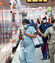 Passengers wear masks while boarding METRORail.
