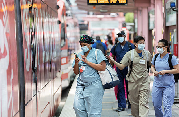 Passengers wear masks while boarding METRORail.