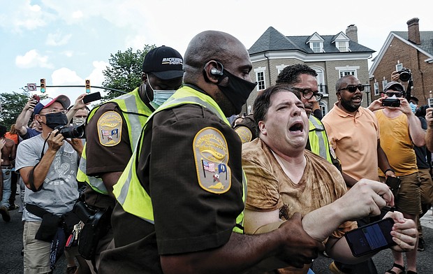 Richmond sheriff’s deputies lead away Meade Skelton after he made a failed effort to stop the removal of the “Stonewall” Jackson statue Wednesday.