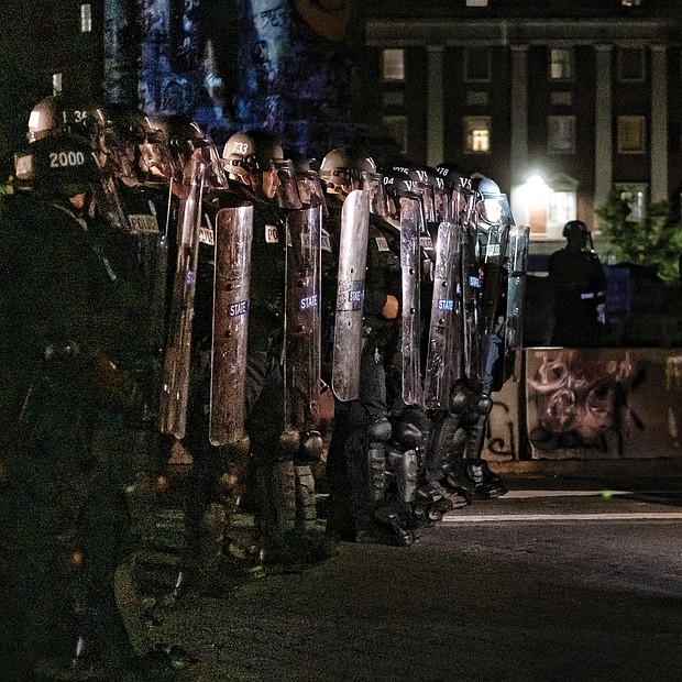 A protester confronts Virginia State Police troopers, who declared an unlawful assembly before pepper-spraying peaceful protesters and bystanders last Friday.