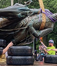 A crew carefully places the bronze statue on a truck. Mayor Levar M. Stoney ordered the removal of remaining Confederate statues as a public safety measure.