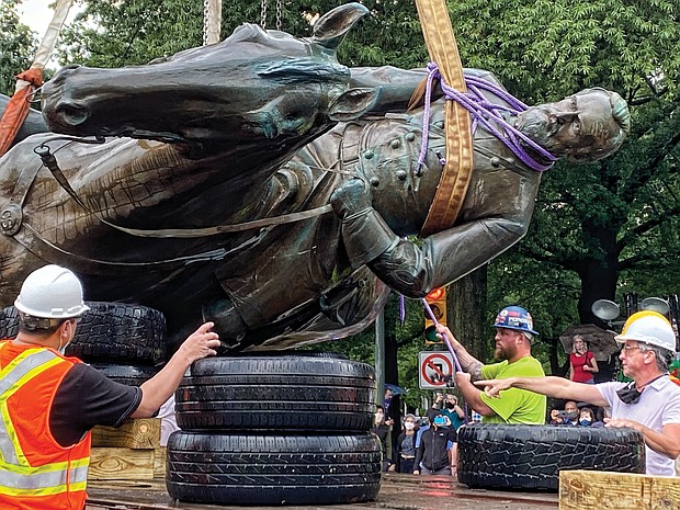 A crew carefully places the bronze statue on a truck. Mayor Levar M. Stoney ordered the removal of remaining Confederate statues as a public safety measure.